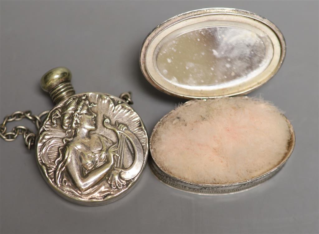 An early 20th century French white metal oval compact, 57mm and a silver plated scent flask.